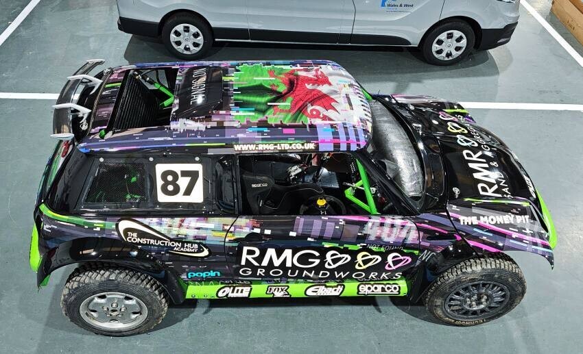 Full vehicle wrap and sponsor graphics including roof coverage on a sports rally race car.
