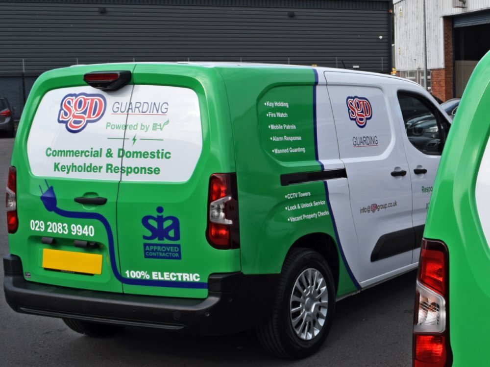Rear end of electric Toyota Proace electric van with green wrap and company graphics.