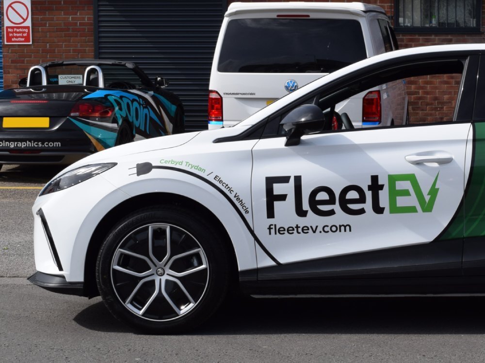 Business vinyl graphics on white company MG4 Trophy EV car.