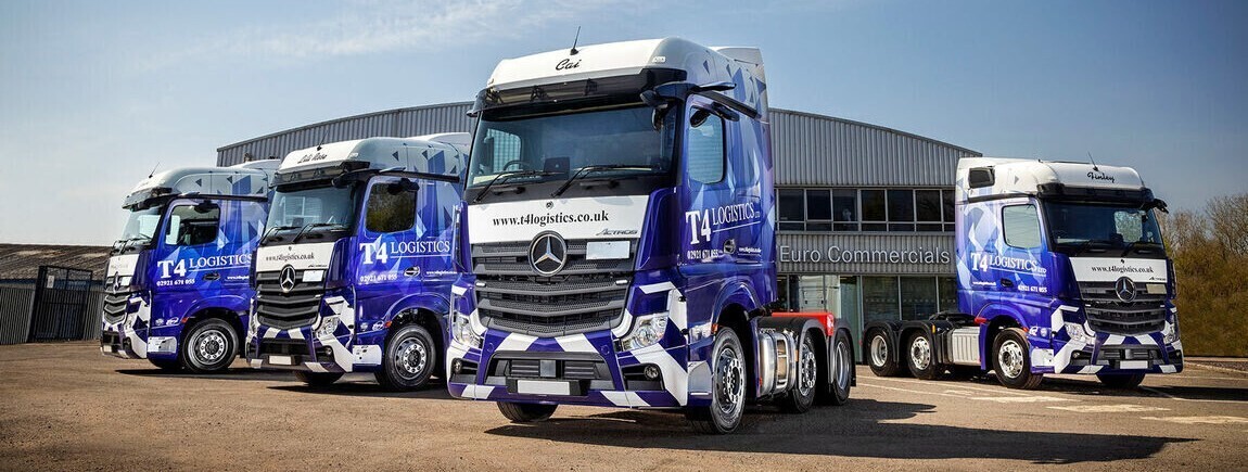 Fleet of blue Mercedes trucks with matching vinyl wraps.