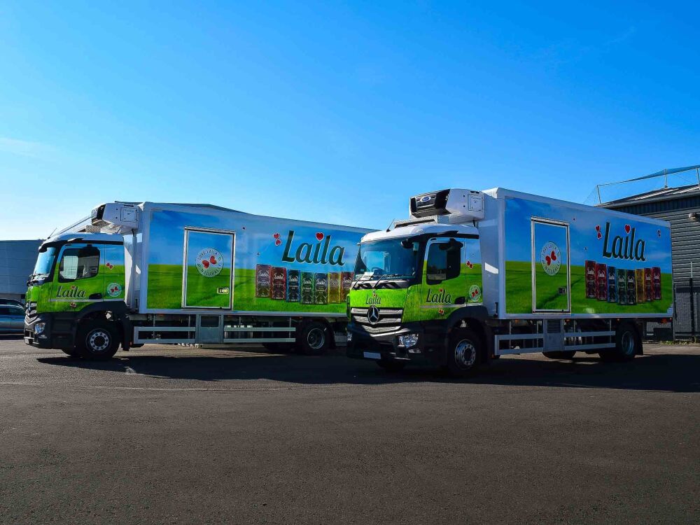 Fleet of Mercedes Actros trucks with matching branded wraps for Surya Foods.