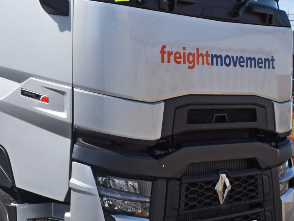 Vinyl graphics on the front end of a silver Renault lorry.