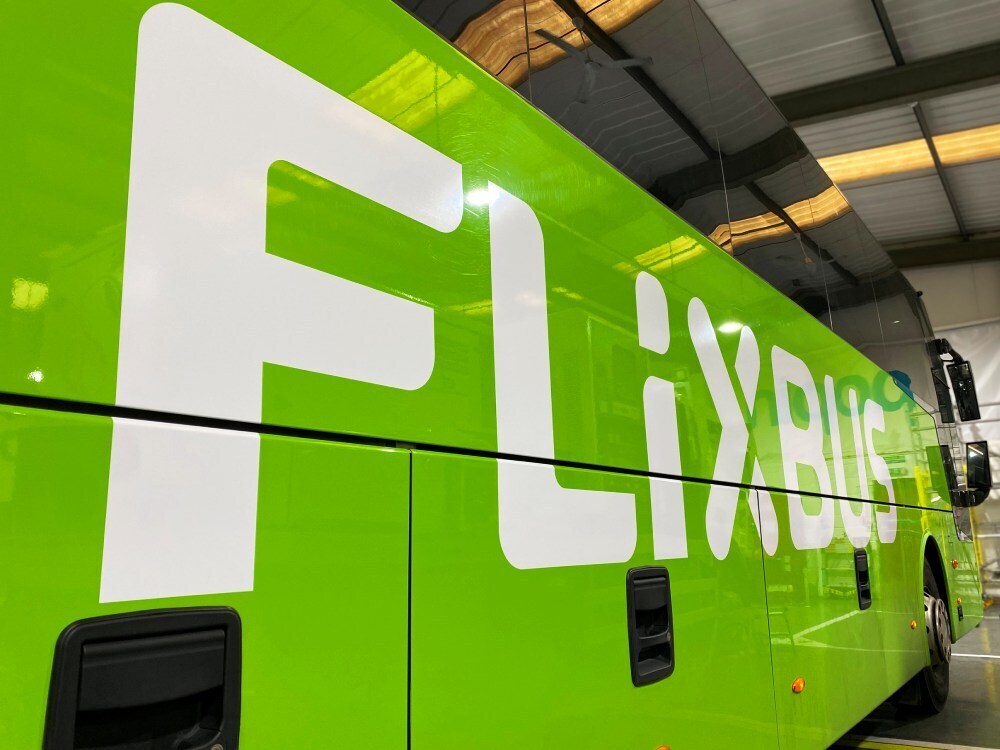 Bright green Flixbus branded vehicle wrap and graphics on Van Hool coach.