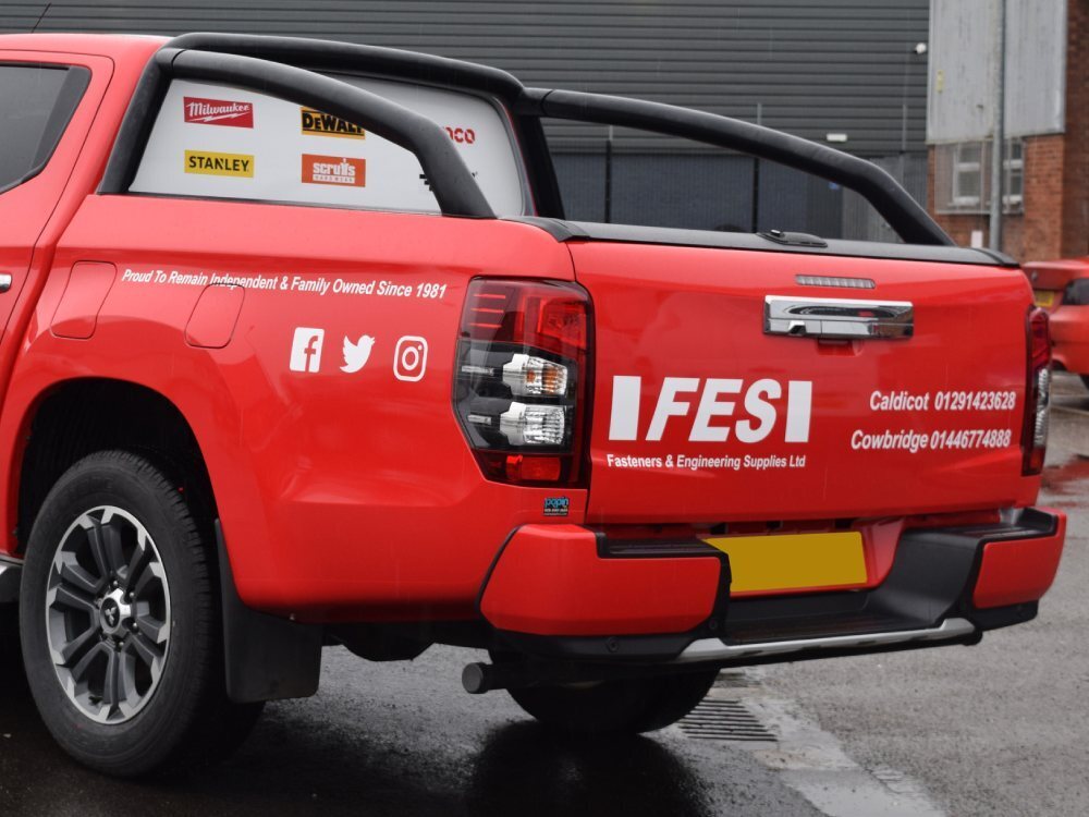 Red vehicle wrap and white graphics on rear of Mitsubishi L200.