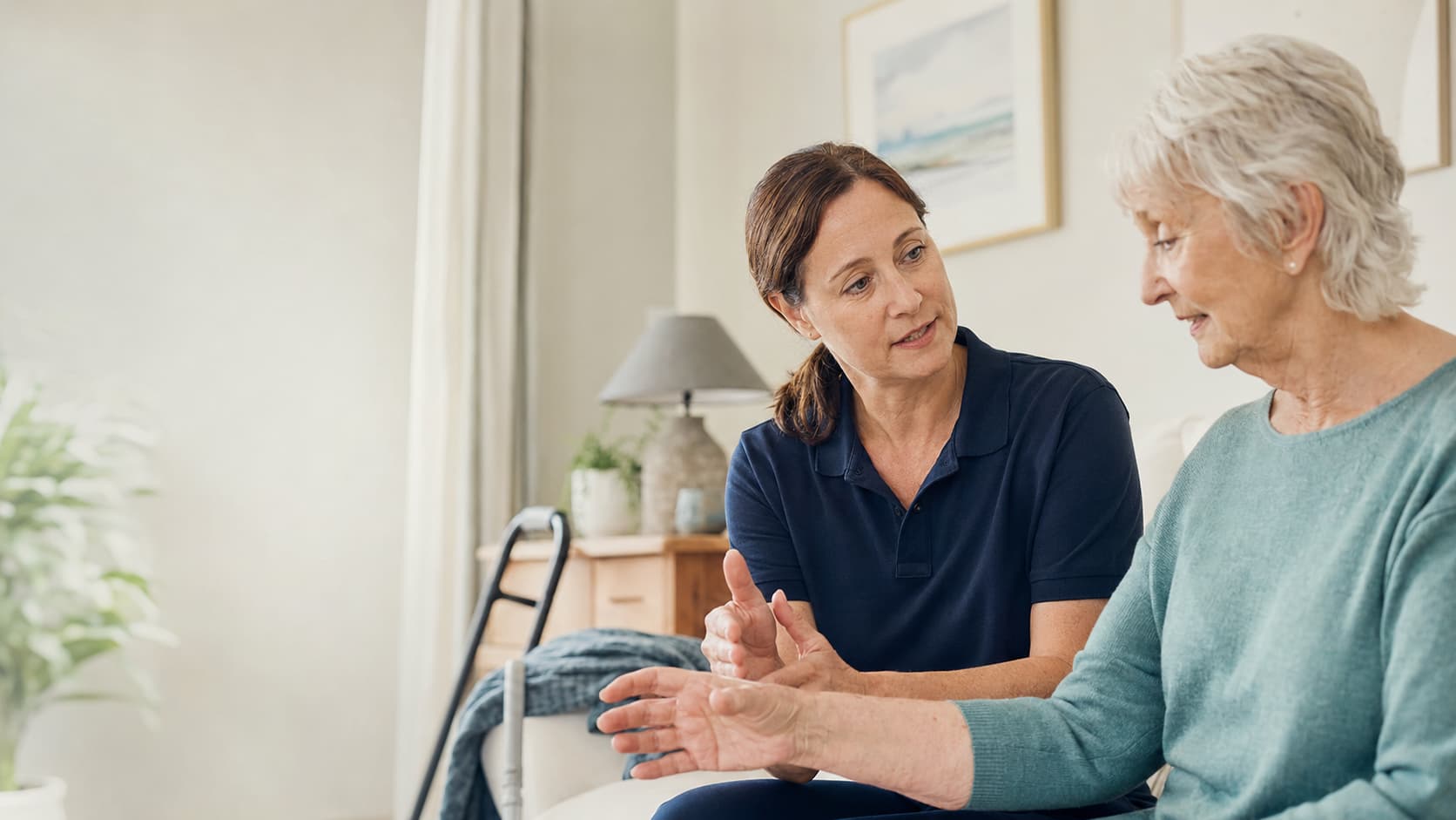 Specialist physiotherapist speaking with an older client during a home physiotherapy visit