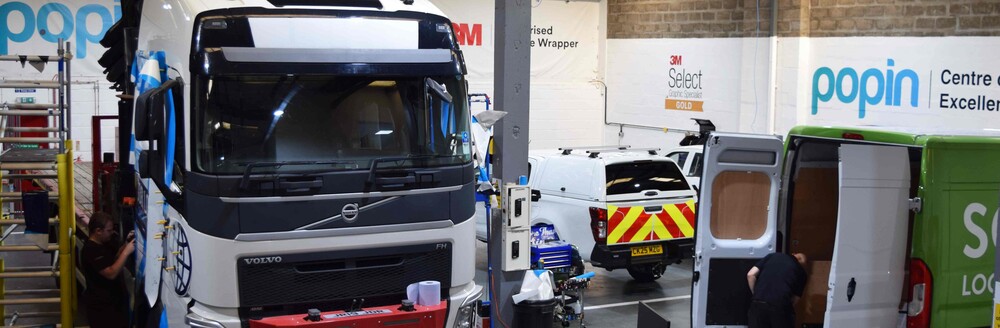 Large vehicle and company vans being wrapped with branded liveries and graphics at Popin vehicle wrap centre in Cardiff.