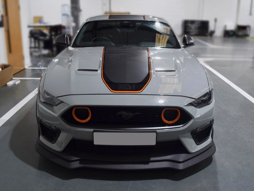 Grey motorsport wrap with black and orange trim detailing on a Ford Mustang Mach 1 sports car
