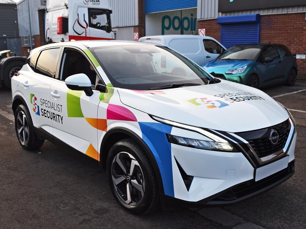 White company Nissan Juke with colourful branded vinyl graphics.