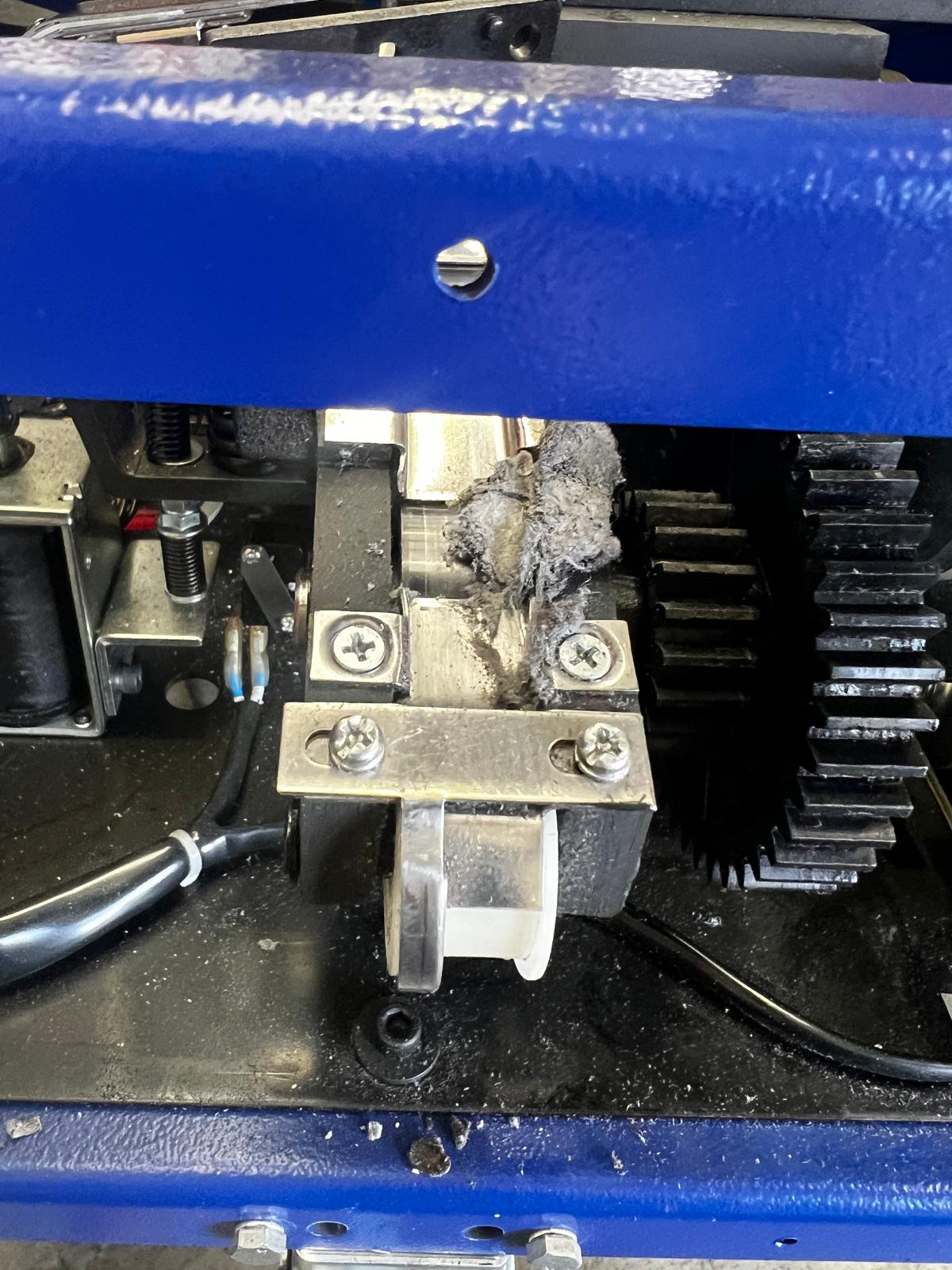 Debris build-up from unsuitable hand strap used in a strapping machine