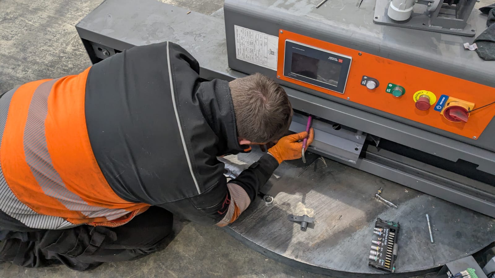 Engineer carrying out on-site repair to packaging machine