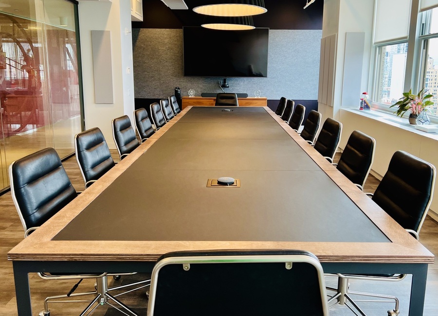 Conference table in a meeting room in New York with a forbo furniture linoleum top with wooden edges leather armchairs from CB2