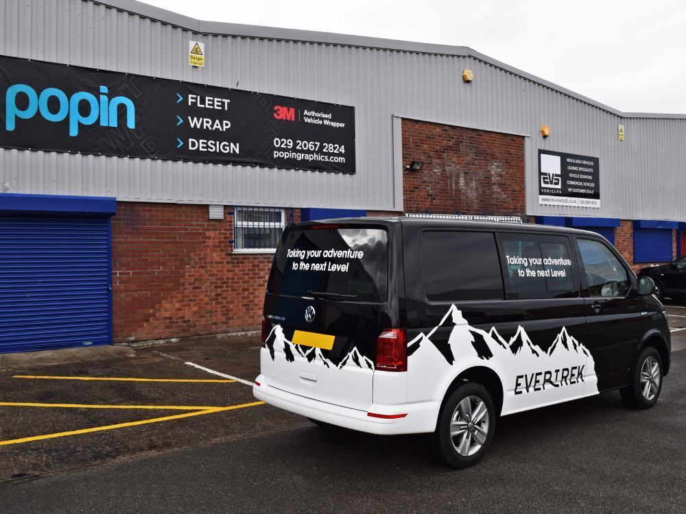 White mountain scene vehicle vinyl graphics on black company Volkswagen Transporter van outside Popin wrap centre in Cardiff.