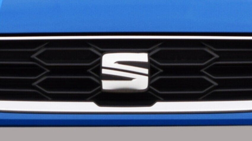 SEAT vehicle badge on front of blue company car.