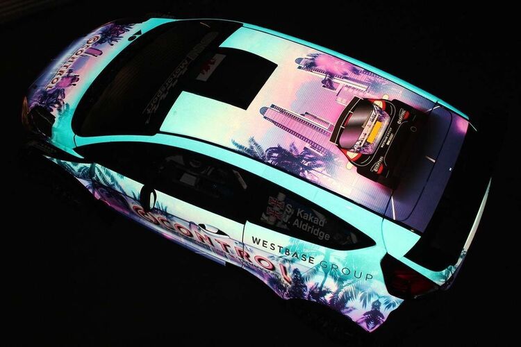 Reflective vinyl film on a race car in the dark.