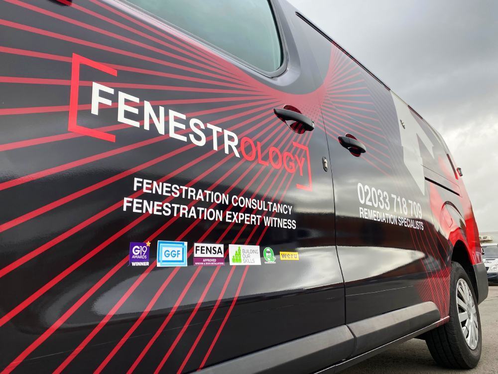 Red striped van wrap design on black Vauxhall Vivaro company vehicle.