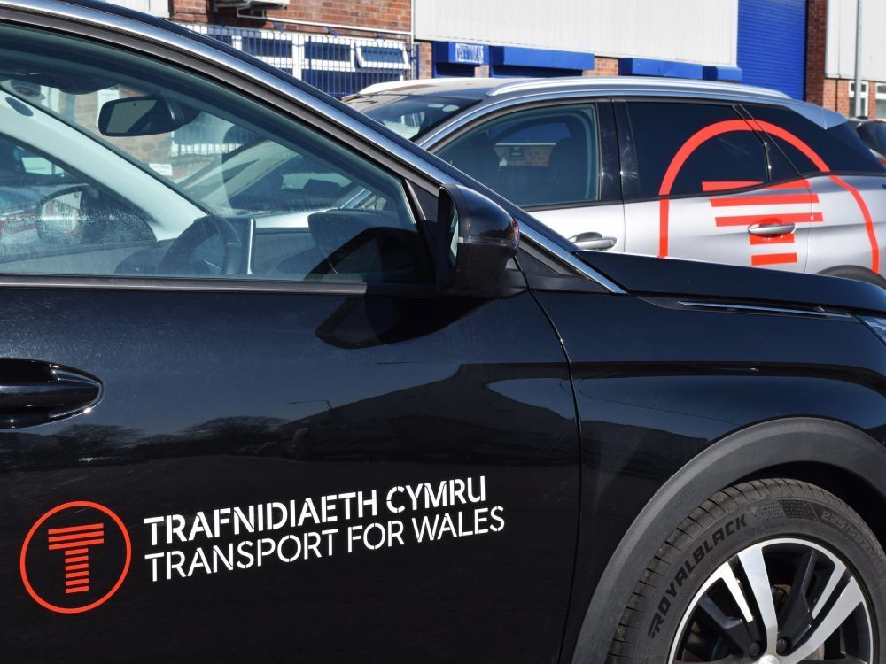 Branded vinyl graphics on side of company Peugeot 3008 cars.