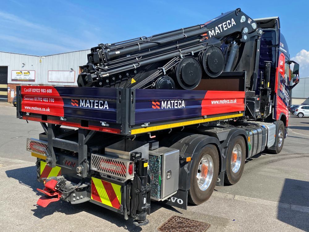 Branded vehicle graphics on a Volvo truck and machinery.