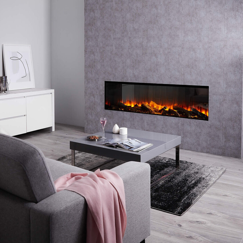 Living room styled in grey with a pink throw, white coffee table and a real log effect electric fire inset into the far wall
