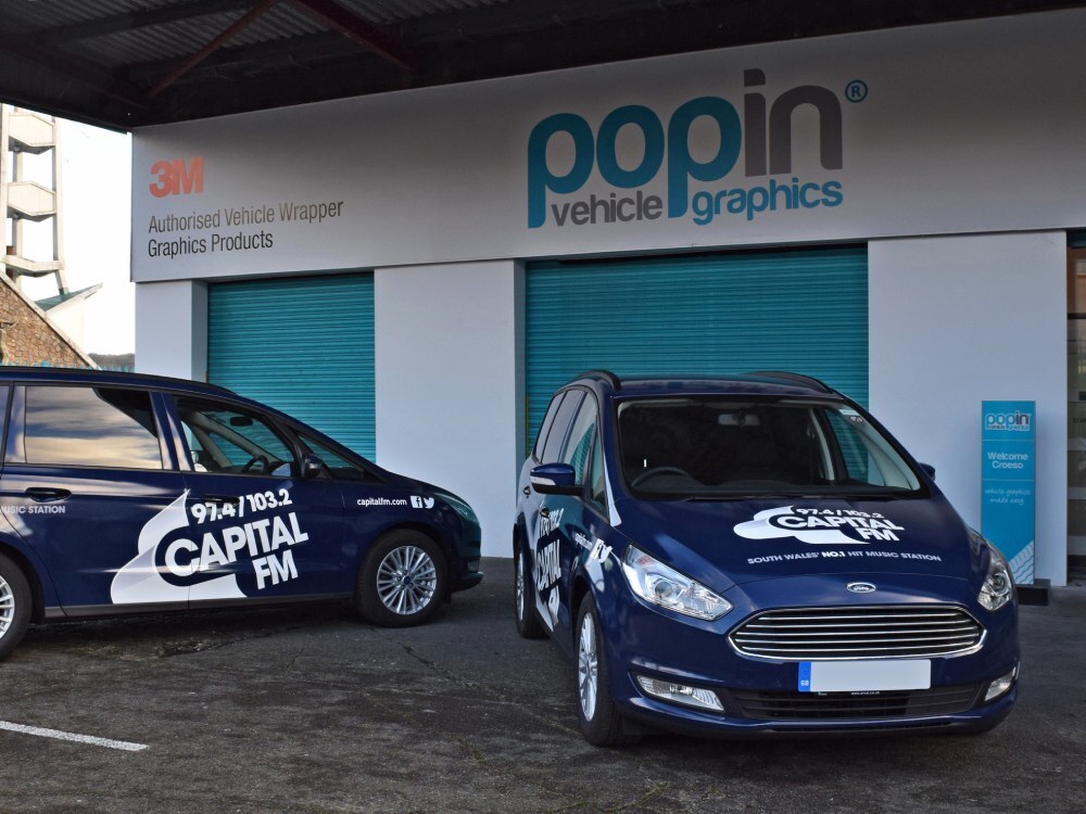 Fleet of branded cars with matching vehicle graphics outside Popin in Cardiff.