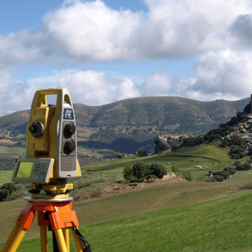 How does terrain affect topographical survey accuracy?