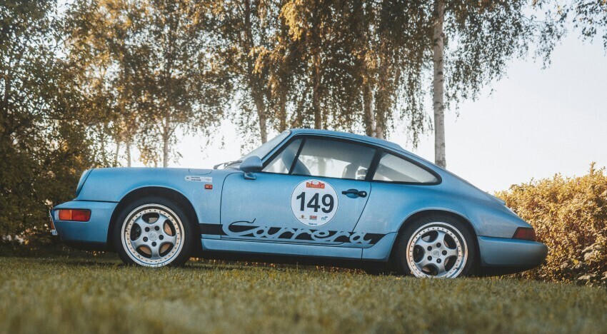 Custom motorsport vinyl vehicle graphics on a blue Porsche 911 race car