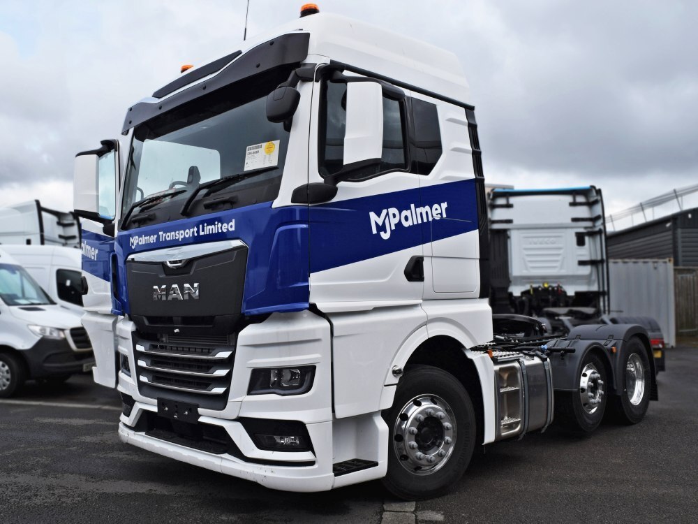 Blue and white vehicle livery newly installed on a MAN lorry.