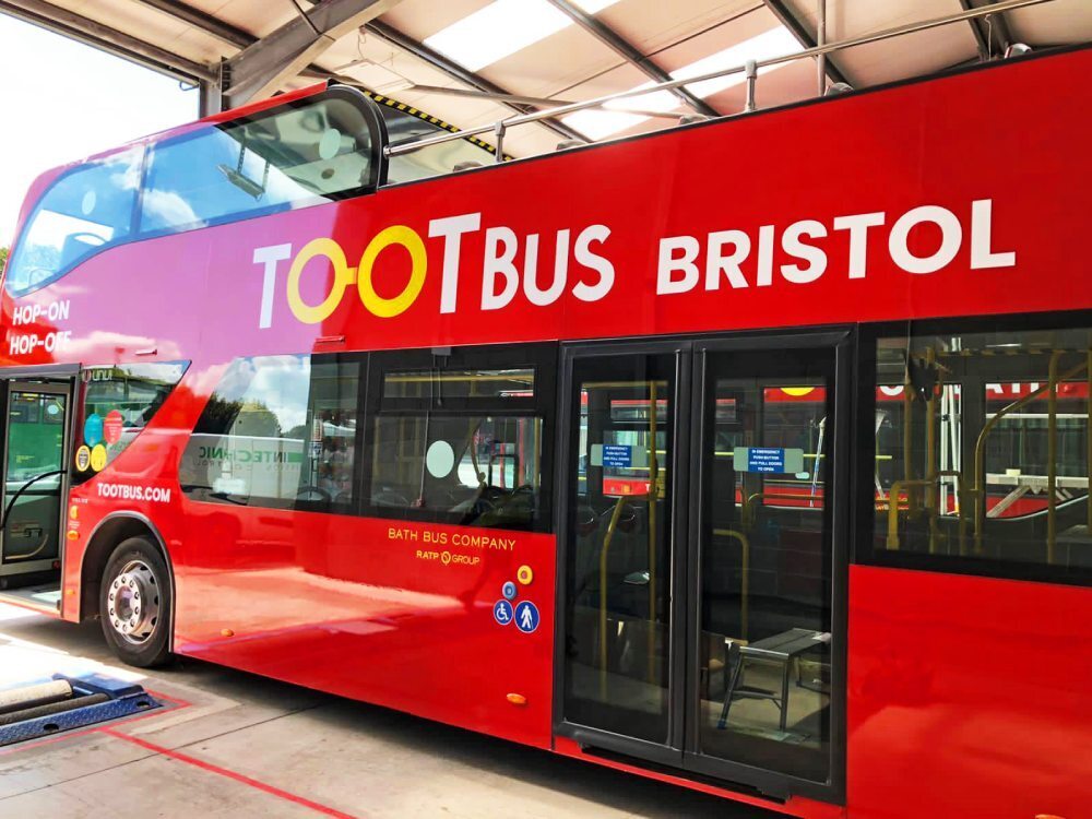 Tootbus branded vehicle graphics on red UNVI Urbis open top tour bus.