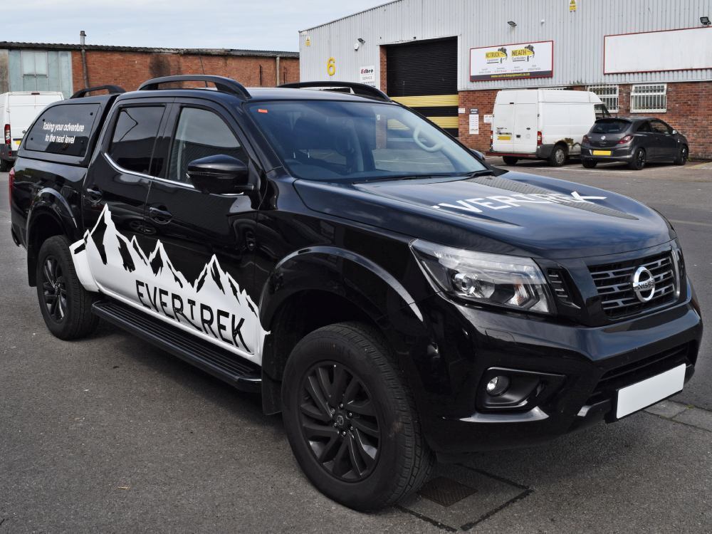 Black Nissan Navara with company branded vehicle graphics.
