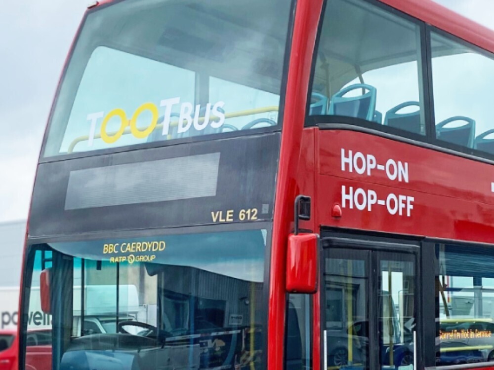 Tootbus company branded vehicle and window vinyl graphics on red Ayats Bravo city open top bus.