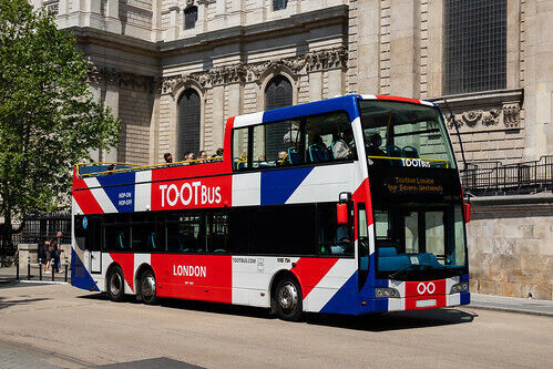 A vibrant Union Jack design vehicle wrap on a Tootbus London Optare VXE open top tour bus.