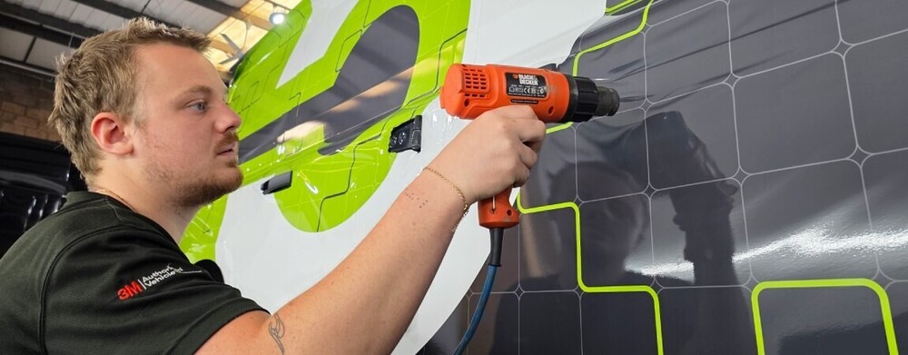 Vinyl wrap applied with heat gun for paint-safe finish on leased commercial van.