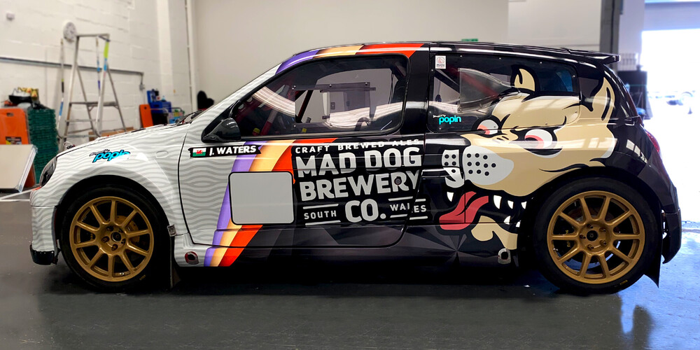 Renault Clio V6 with custom vehicle wrap branding for Mad Dog Brewery Co