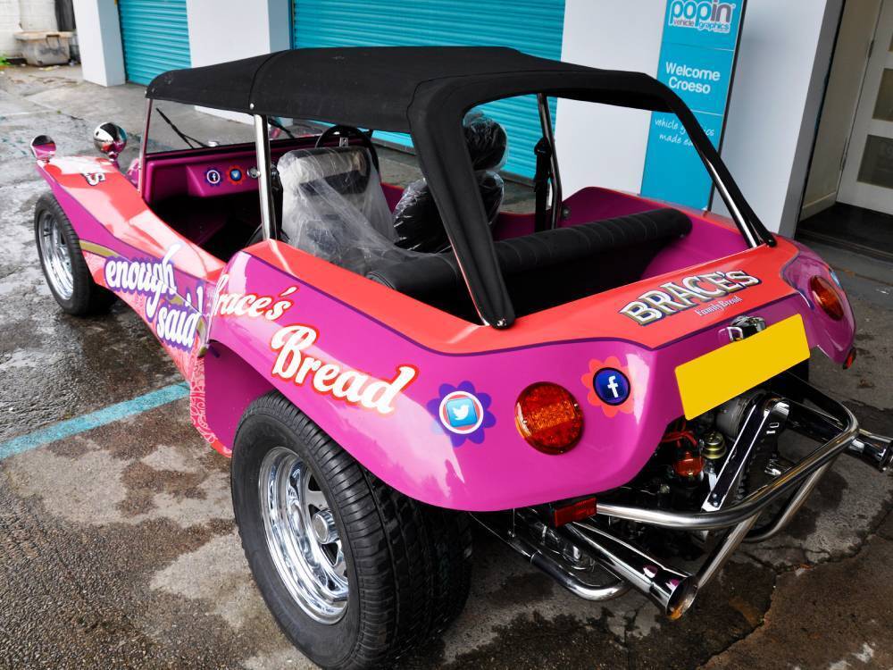 Volkswagen Meyers Manx company car with pink branded vehicle wrap.