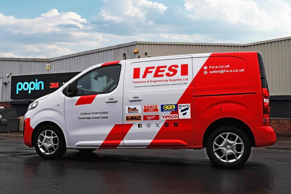 Red and white vehicle wrap and graphics on a company Citroen Dispatch van outside Popin in Cardiff.