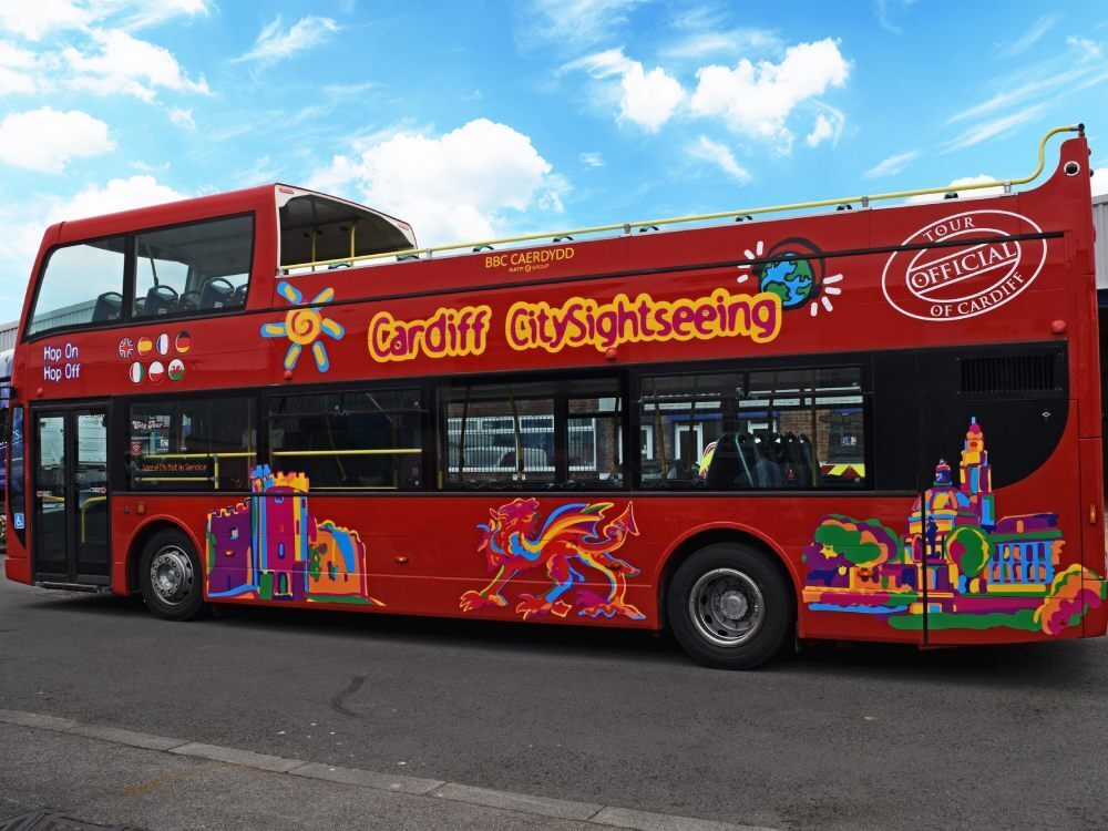 Red Optare VLE open top tour bus with Cardiff City Sightseeing branded graphics.