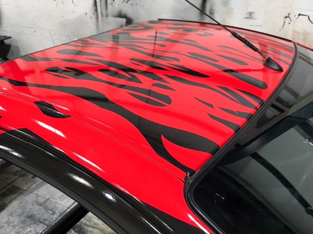 Red and black flame graphics installed of roof of a Ford Focus race car