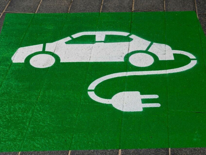 Green electric vehicle charging sign painted on the floor.