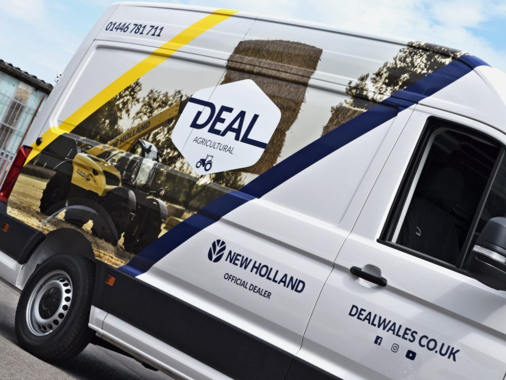 Side of a white company MAN TGE van with branded vehicle wrap and graphics.