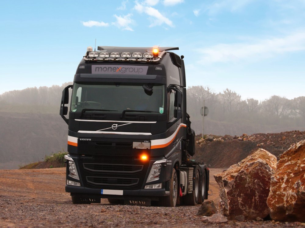 Vehicle wrap and vinyl graphics on a Volvo lorry as it drives through a rural area.