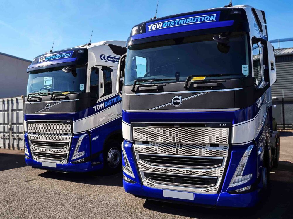 Fleet of Volvo FH5 trucks with matching vehicle wraps and graphics for TDW Distribution.