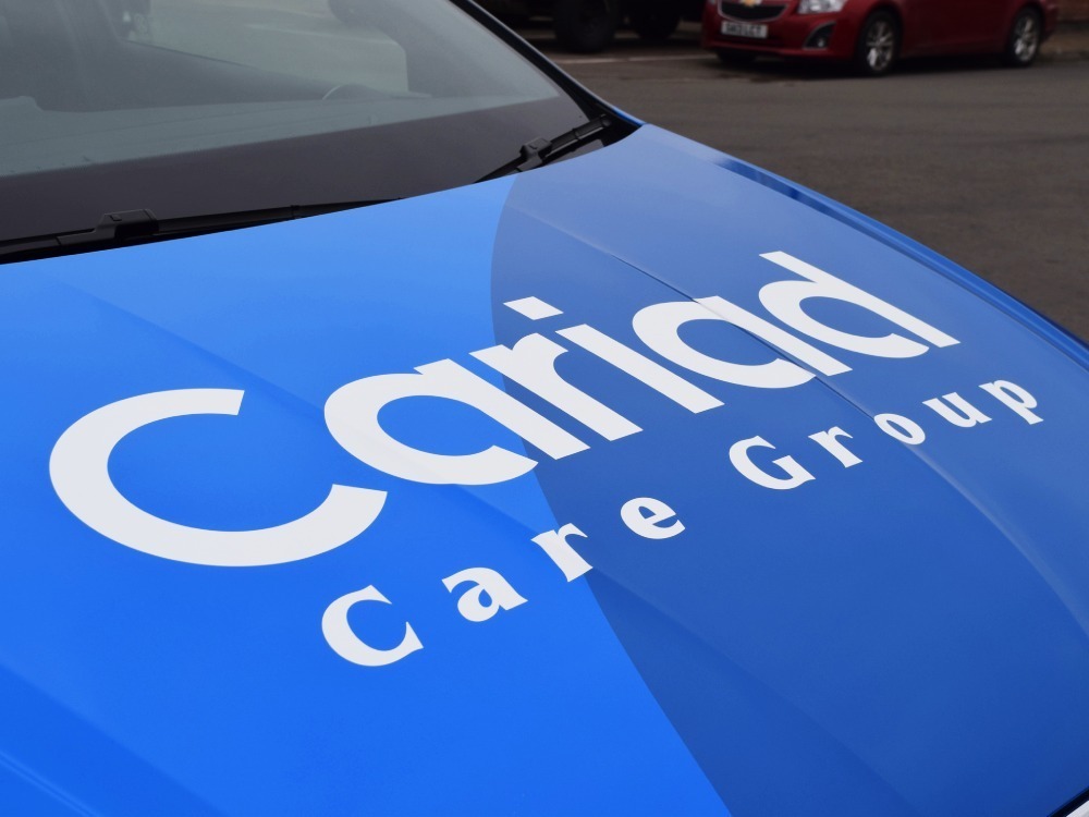 White branded vinyl graphics on bonnet of blue SEAT Ibiza company car.