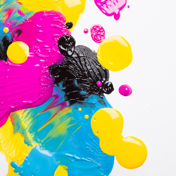 Abstract artwork with splashes of yellow, pink, black, and blue on white, shown as an example of sublimation printing inks.
