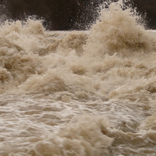 How can topographical surveys aid in flood risk assessments?