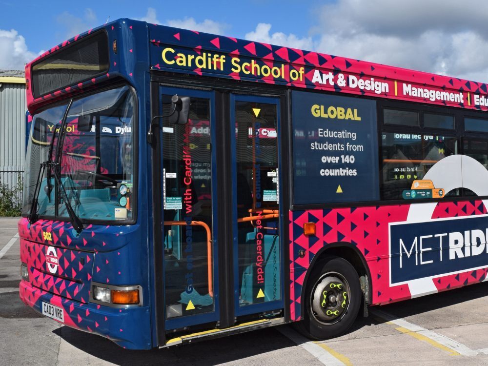 Front of Dennis Dart bus with bold branded vehicle livery and promotional graphics.