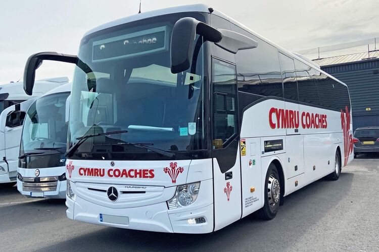 Cymru Coaches Mercedes Tourismo with white livery and red branded vinyl graphics.