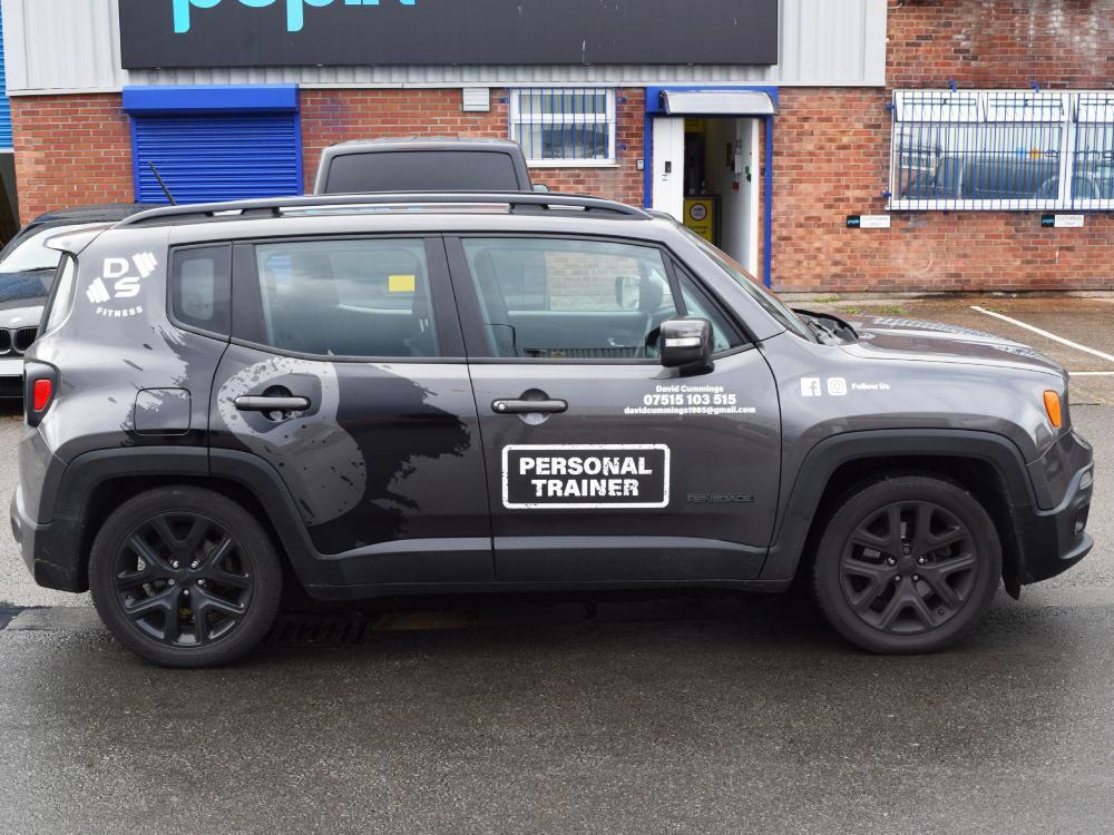 Company branded vinyl graphics on grey Jeep.