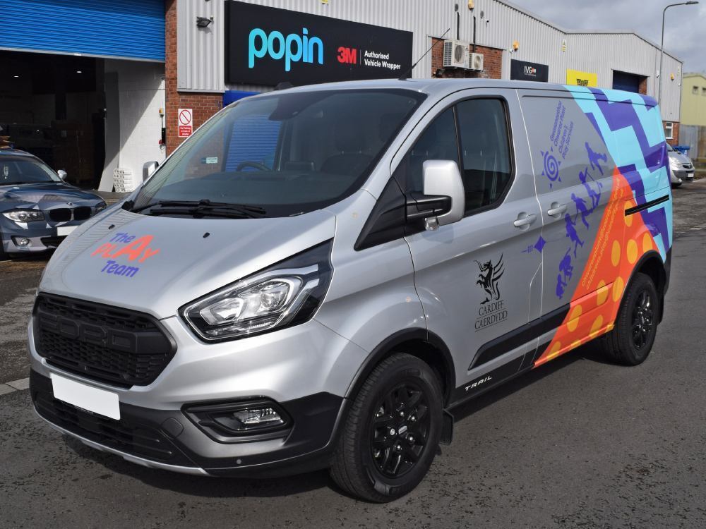 Silver Cardiff City Council Ford Transit Custom van with partial vehicle wrap and graphics.