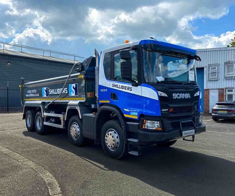Vinyl graphics for vehicle business branding on a blue Scania P Series truck