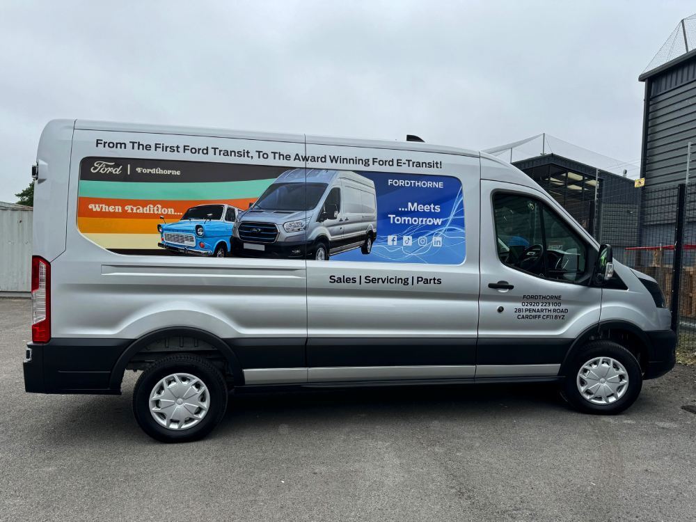 Ford E-Transit electric company van with promotional recess vinyl graphics.