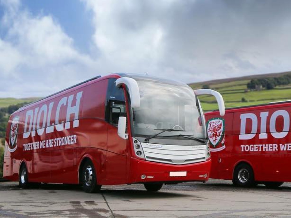 Red and white Caetano Levante coach with FA Wales branded vehicle graphics.